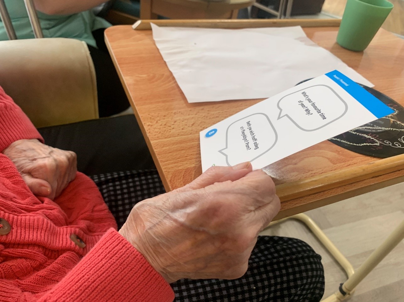 Woman holding a tell me more conversation card