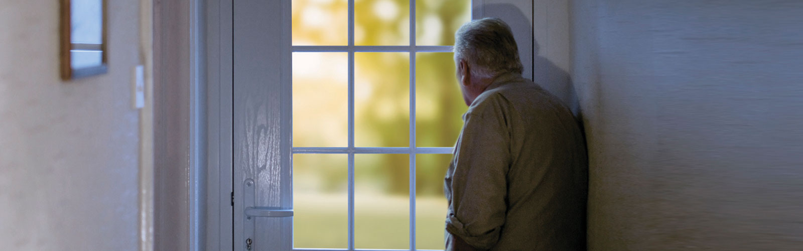 An older man looking out of a window 