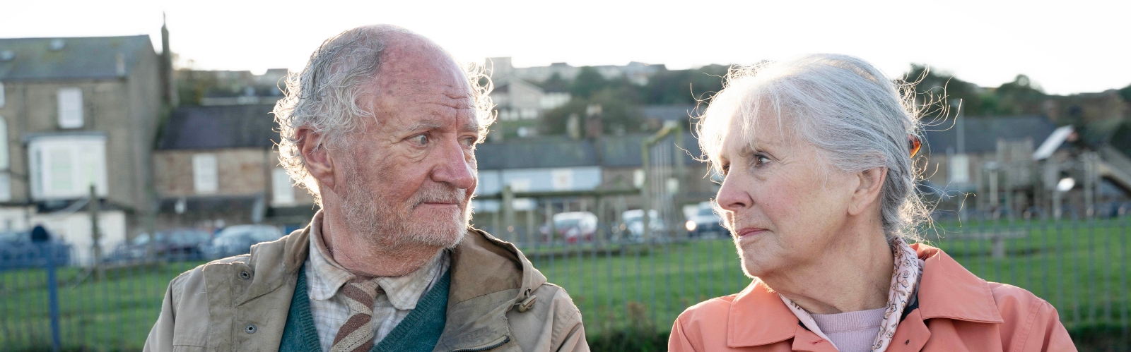 An image of Jim Broadbent and Dame Penelope Wilton smiling at each other