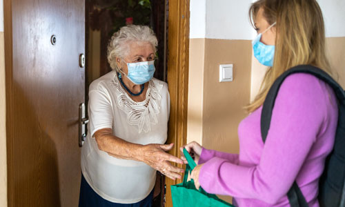 A woman makes a delivery to an older woman at her home