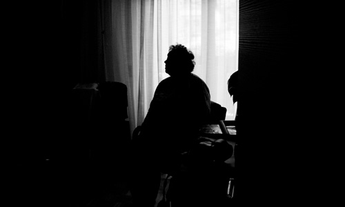 A woman sat in a darkened room