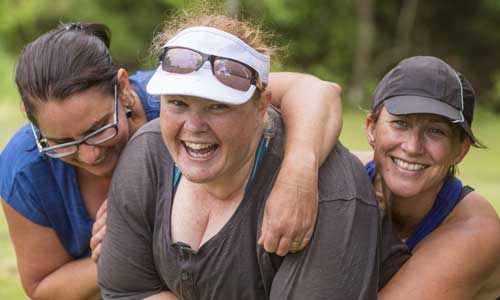 A group of women hug each other after completing a sporting challenge