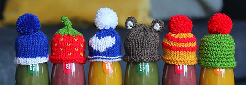 Knitted hats on innocent smoothie bottles